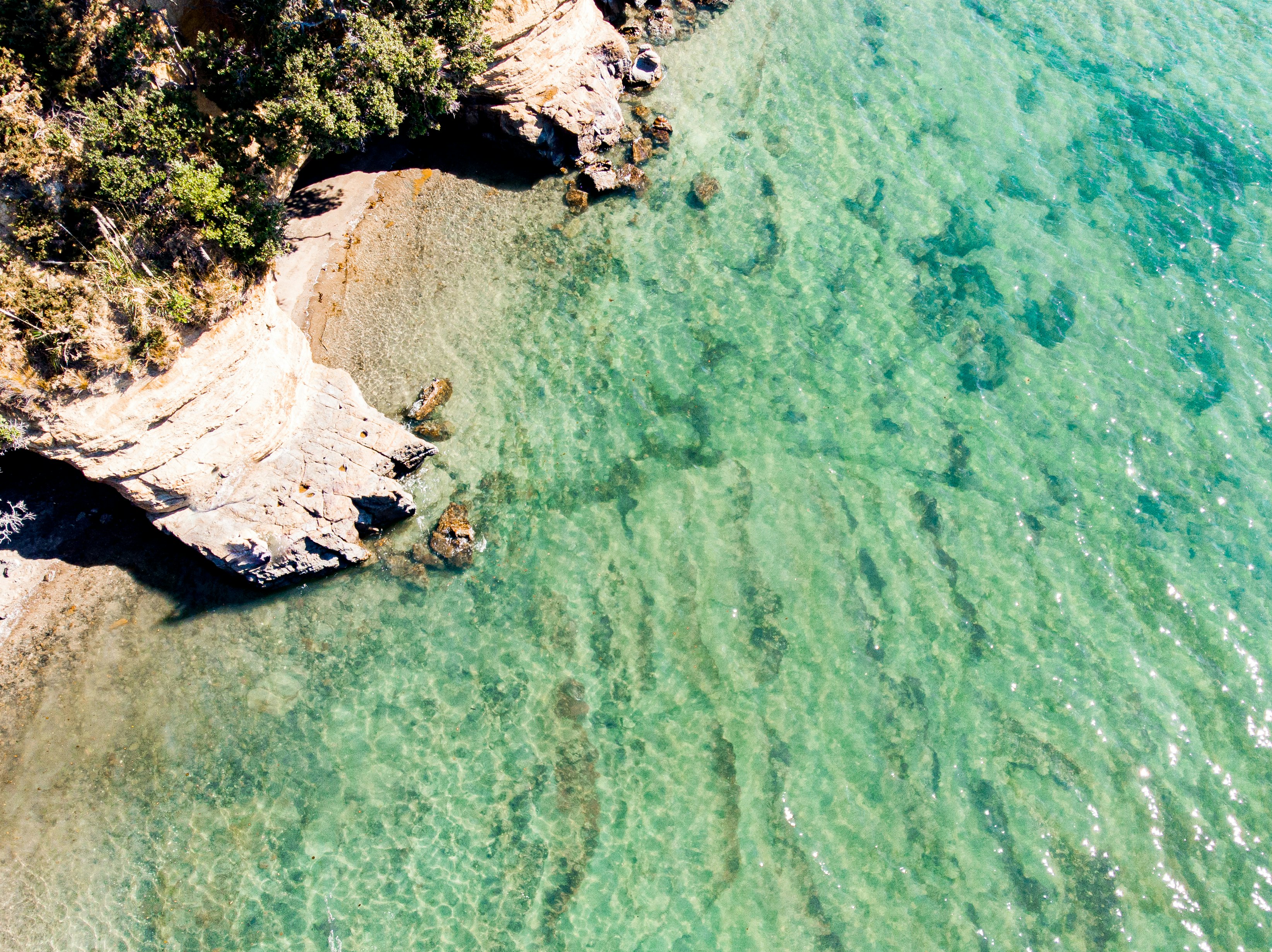 aerial view of white and brown rock formation on body of water during daytime